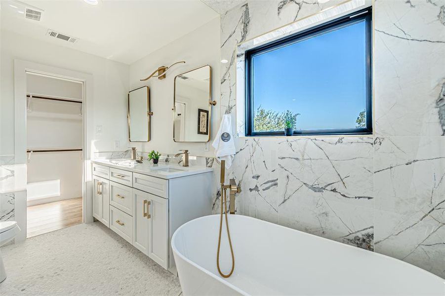 Bathroom featuring double vanity and a freestanding tub