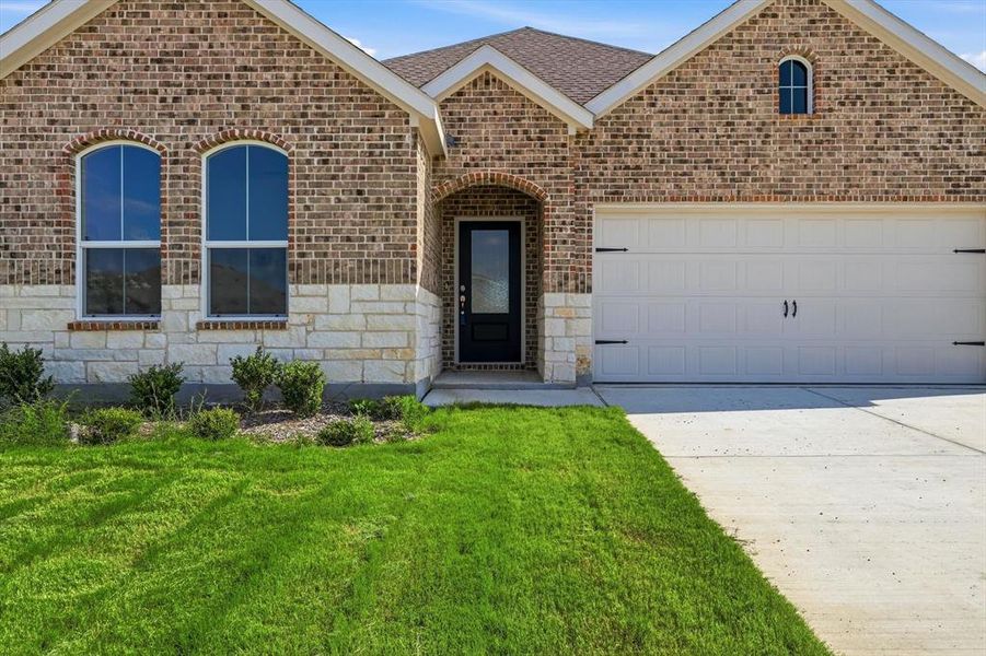 Brick and stone facade featuring arched windows and an arched entry Brick and stone facade featuring arched windows and an arched entry