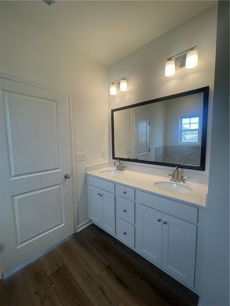 This modern bathroom features a dual vanity, sleek