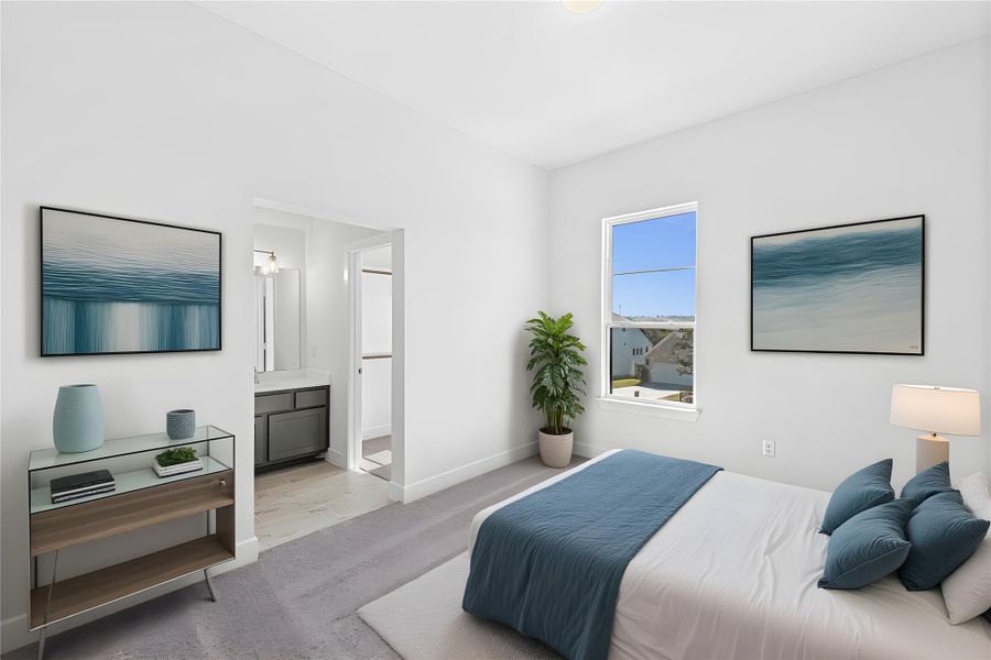 Bedroom with ensuite bath and light carpet