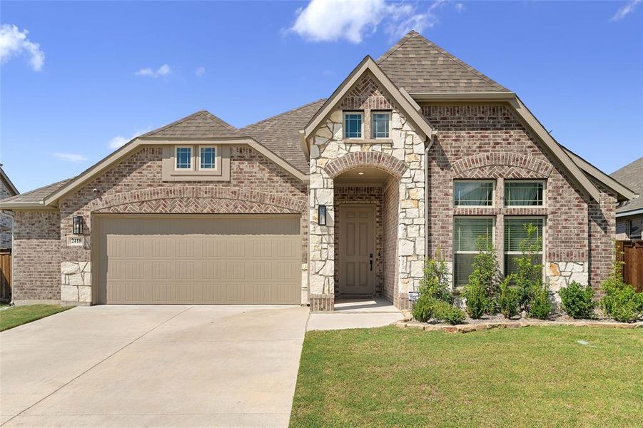French country style house with brick siding, roof with shingles, stone siding, concrete driveway, and an attached garage French country style house with brick siding, roof with shingles, stone siding, concrete driveway, and an attached garage