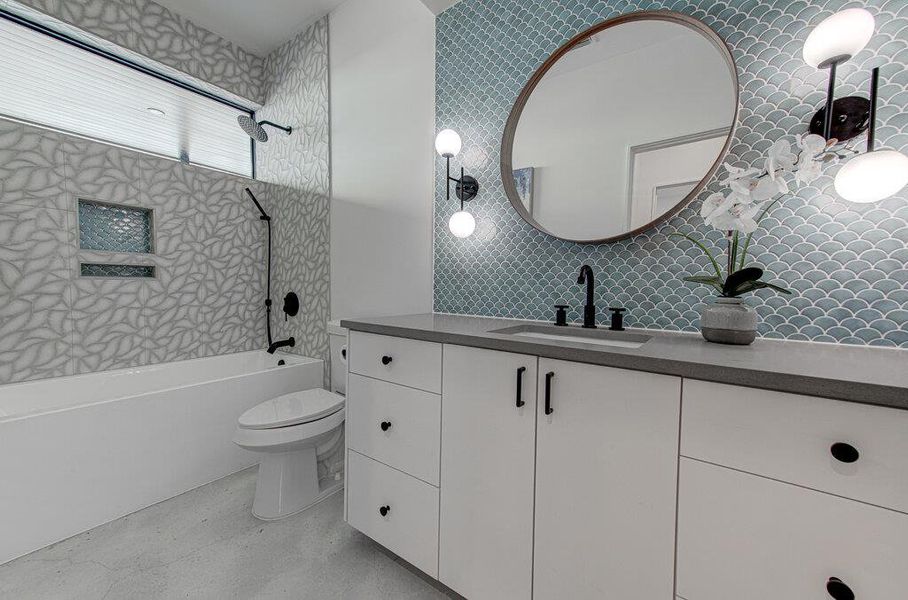 Bathroom with toilet, backsplash, vanity, and washtub / shower combination