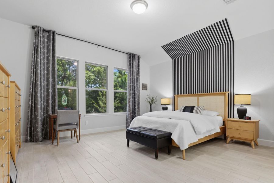 A serene retreat defined by a spectacular homeowner-installed geometric accent wall and a wall of windows overlooking the private backyard.