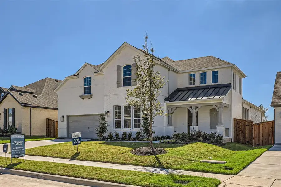 View of front facade featuring a front yard and a garage