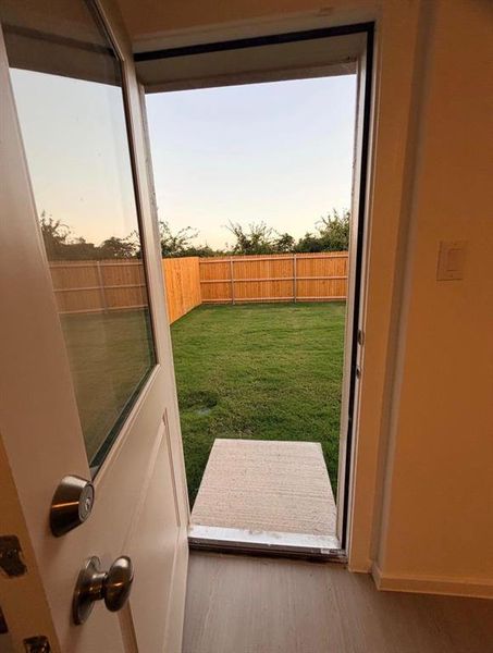 Expansive backyard featuring a manicured lawn, full privacy fencing, and mature perimeter trees Expansive backyard featuring a manicured lawn, full privacy fencing, and mature perimeter trees