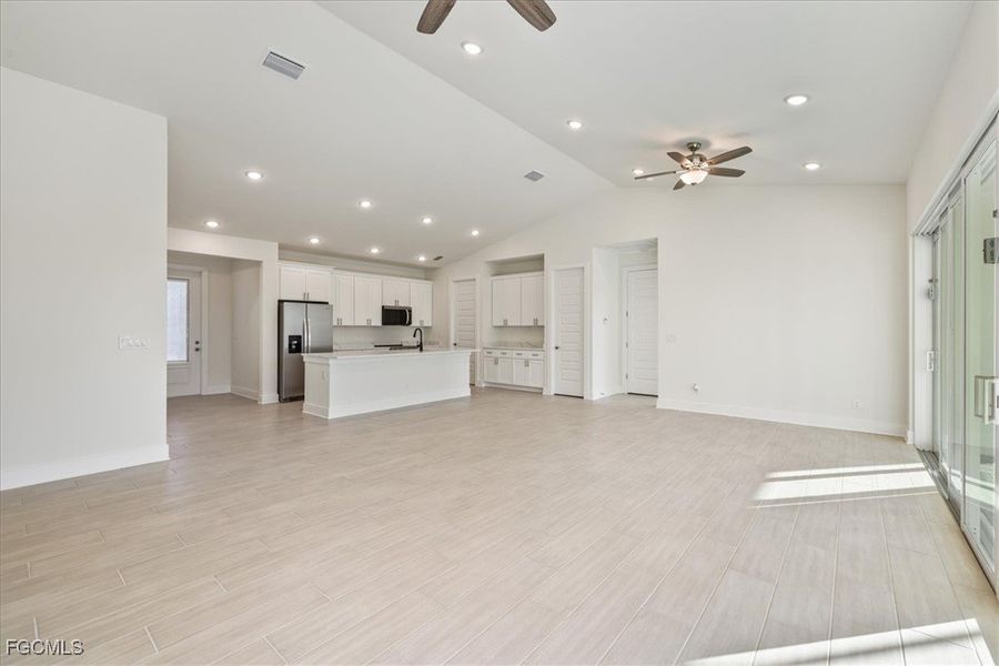 Unfurnished living room with recessed lighting, lofted ceiling, ceiling fan, and wood tiled floors