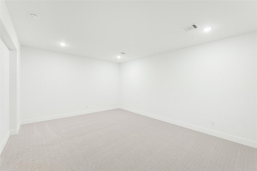 Empty room with white walls, beige carpet, and recessed ceiling lights