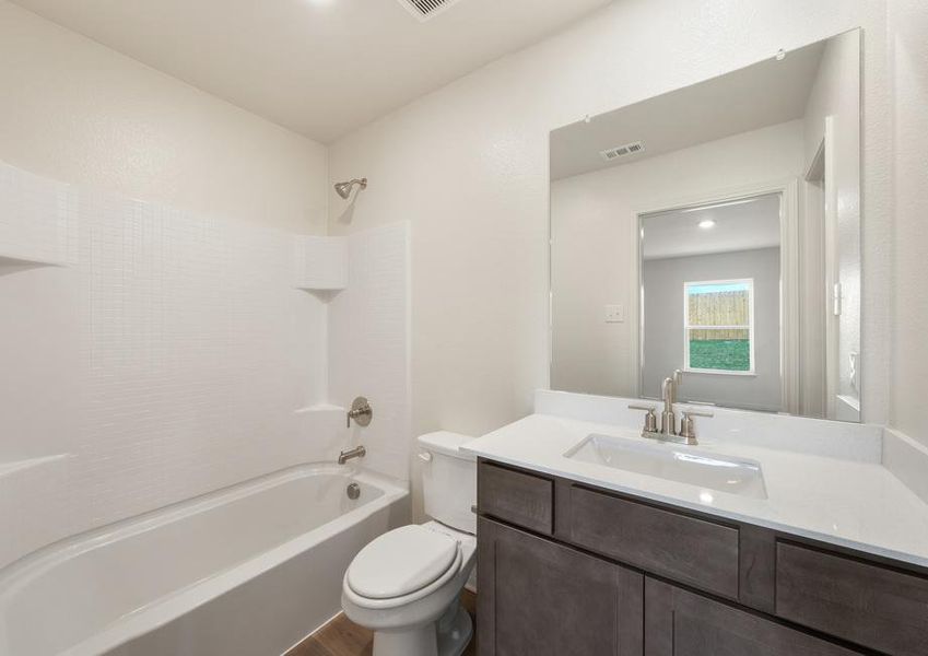 The master bathroom has a large vanity space and a shower-tub combo.