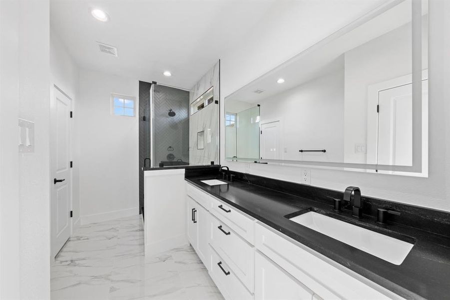 Full bathroom featuring marble finish floor, recessed lighting, a sink, and a stall shower