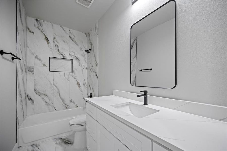 Full bath featuring vanity, visible vents, shower / bath combination, toilet, and marble finish floor