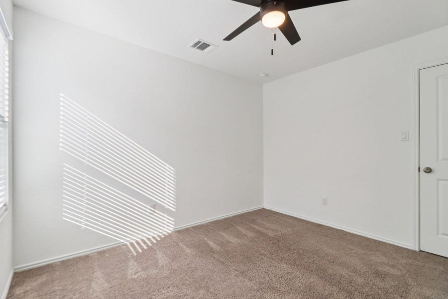 Spare room with ceiling fan and carpet flooring