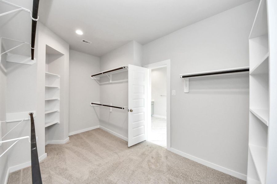 Walk-in closet that epitomizes luxury and practicality. This generously sized space features built-in shelving, offering abundant room for impeccable organization. High ceilings and recessed lighting create a bright and welcoming ambiance. Sample photo of completed home with similar floor plan. Actual colors and selections may vary. Walk-in closet that epitomizes luxury and practicality. This generously sized space features built-in shelving, offering abundant room for impeccable organization. High ceilings and recessed lighting create a bright and welcoming ambiance. Sample photo of completed home with similar floor plan. Actual colors and selections may vary.