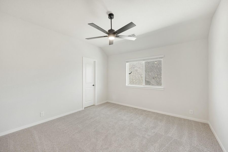 Empty bedroom with vaulted ceiling, ceiling fan, carpet flooring, and single window