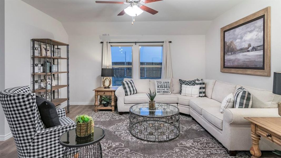 Living area featuring lofted ceiling, dark wood-style floors, and a ceiling fan Living area featuring lofted ceiling, dark wood-style floors, and a ceiling fan