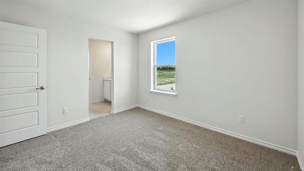 Unfurnished bedroom featuring light carpet and ensuite bathroom
