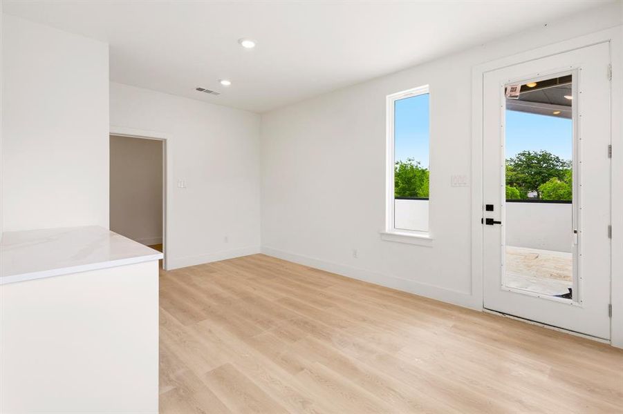 Bright living area featuring light-toned flooring, white walls, and recessed lighting