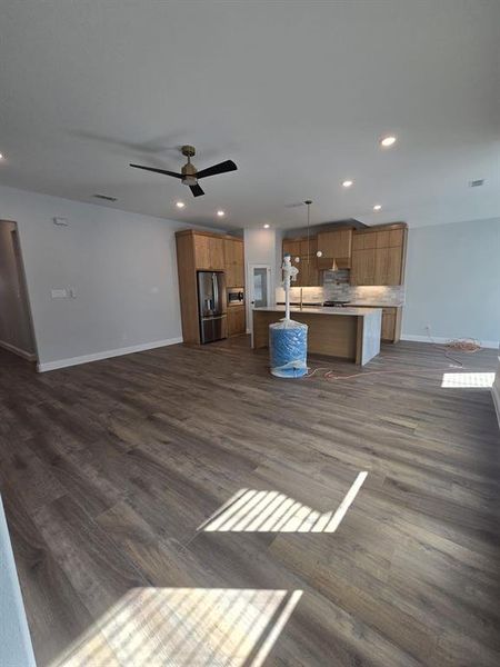 Unfurnished living room with ceiling fan, dark wood-type flooring, and recessed lighting