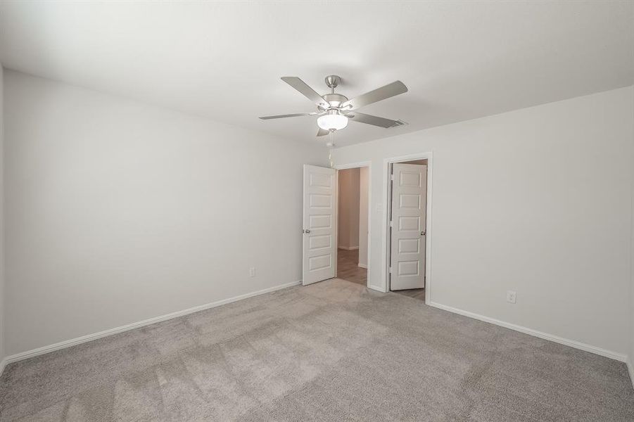 Unfurnished bedroom with carpet flooring and a ceiling fan Unfurnished bedroom with carpet flooring and a ceiling fan
