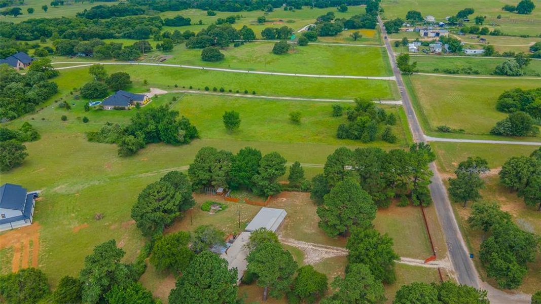 Aerial view highlighting the home's acreage, mature trees, workshop, and peaceful rural setting. Aerial view highlighting the home's acreage, mature trees, workshop, and peaceful rural setting.