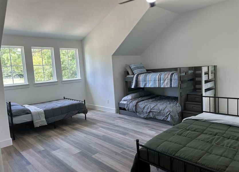 Bedroom with vaulted ceiling and wood finished floors Bedroom with vaulted ceiling and wood finished floors
