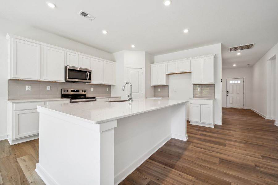 A kitchen with white cabinets.