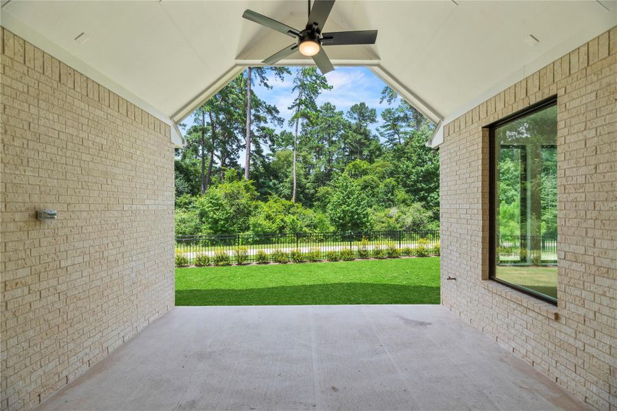 Relax and entertain in style on this covered patio, featuring a vaulted ceiling with fan and peaceful views of the lush greenbelt.