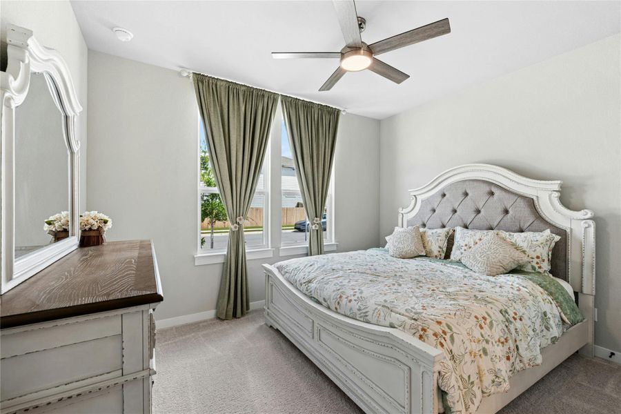Bedroom with light colored carpet and ceiling fan
