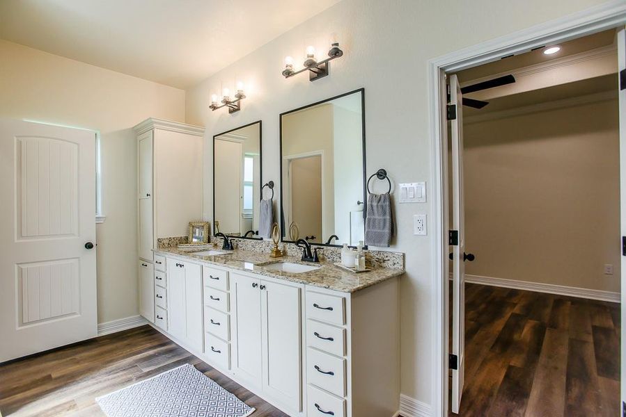 Bathroom featuring double vanity and wood finished floors Bathroom featuring double vanity and wood finished floors