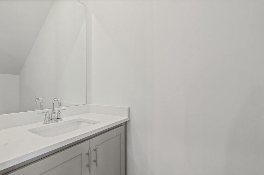 Vanity with a polished countertop, an integrated rectangular sink, and chrome-finish fixtures