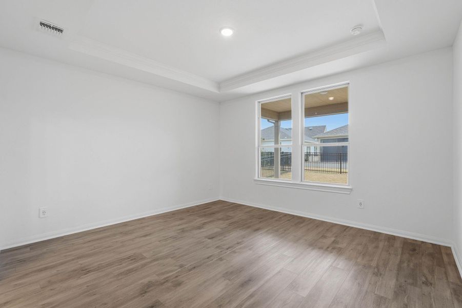 Bright, spacious primary bedroom with large windows that fill the room with natural light and offer backyard views, complete with an ensuite bathroom.