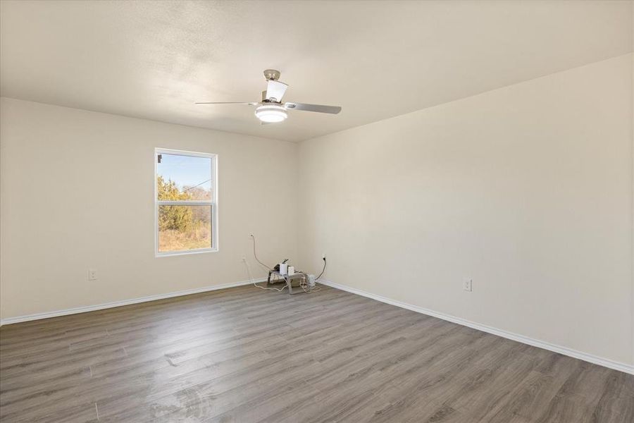 Empty room featuring wood-type flooring and ceiling fan