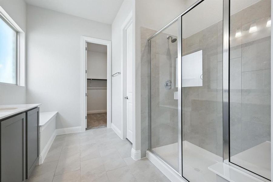 Bathroom with a stall shower, vanity, a walk in closet, and tile patterned flooring Bathroom with a stall shower, vanity, a walk in closet, and tile patterned flooring