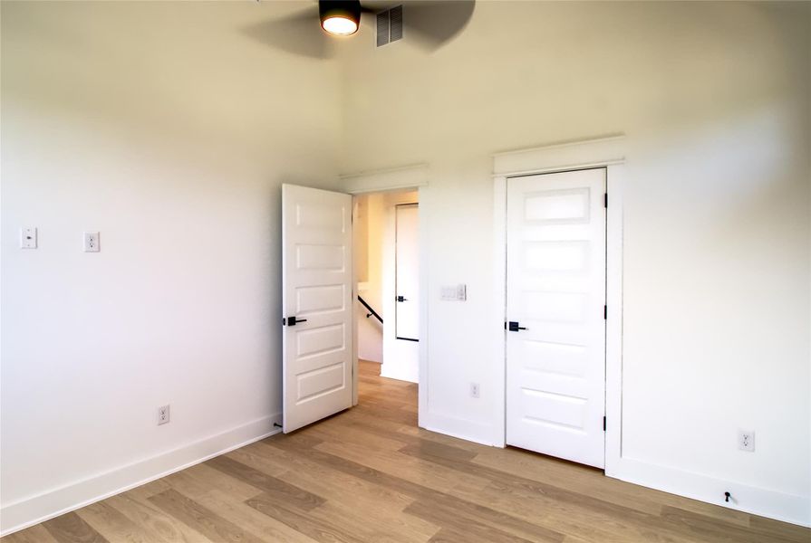 Unfurnished bedroom with wood finished floors and baseboards