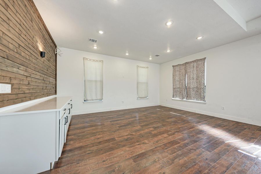Rich wood floors and a horizontal plank feature wall define this versatile interior space.