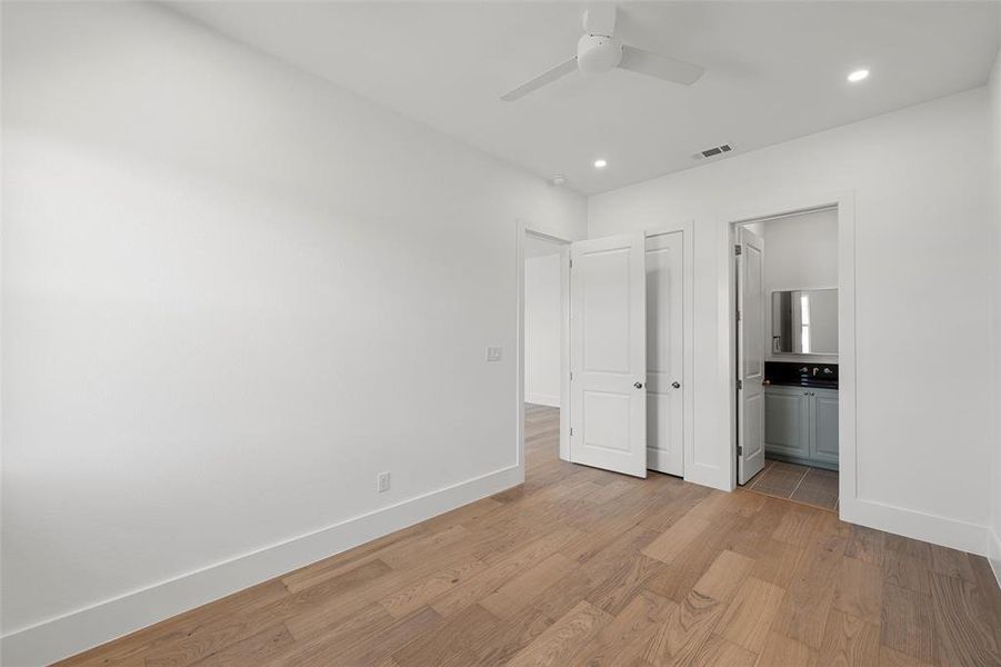 Unfurnished bedroom with light wood-style flooring, recessed lighting, ceiling fan, and ensuite bathroom Unfurnished bedroom with light wood-style flooring, recessed lighting, ceiling fan, and ensuite bathroom
