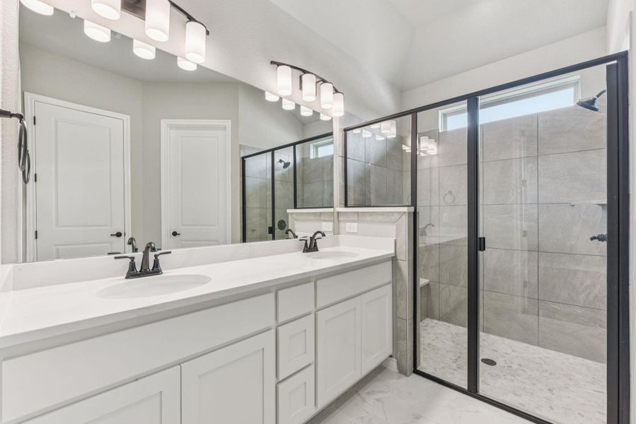 Full bath with a shower stall, double vanity, and light marble finish floors Full bath with a shower stall, double vanity, and light marble finish floors