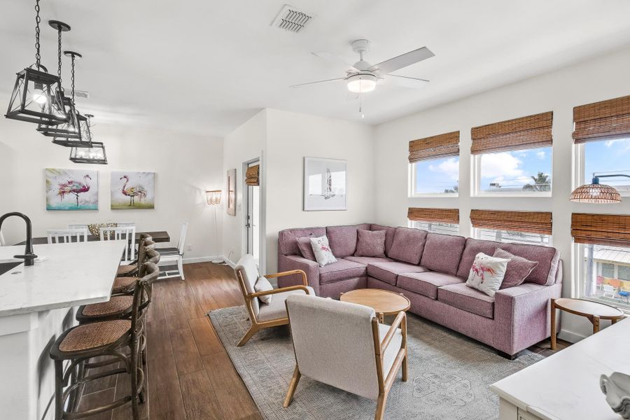 Living area with dark wood-style flooring and a ceiling fan Living area with dark wood-style flooring and a ceiling fan