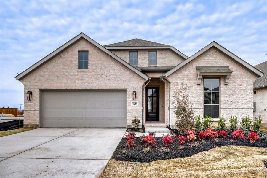 View of front of property featuring concrete driveway, an attached garage, roof with shingles, and brick siding