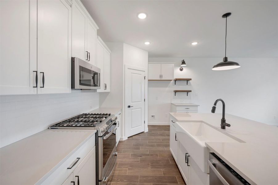 Stylish kitchen with quartz counters and floating shelves