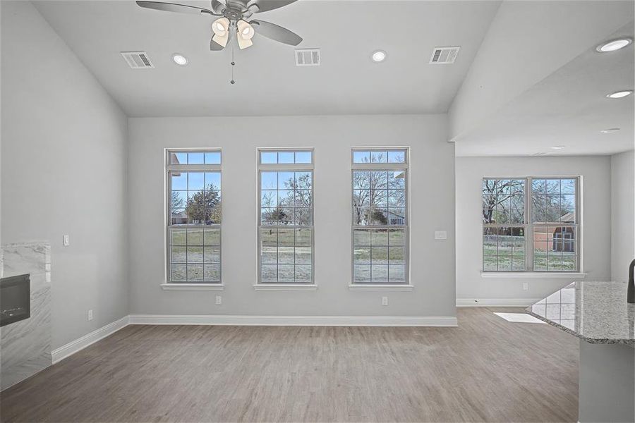 Unfurnished living room with a ceiling fan, light wood-style flooring, recessed lighting, and a fireplace