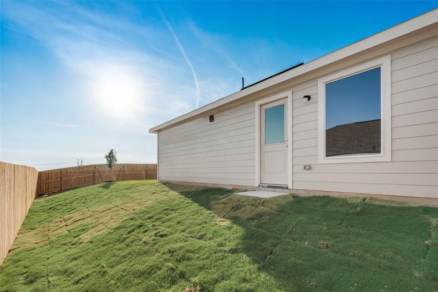 Rear view of house featuring a lawn