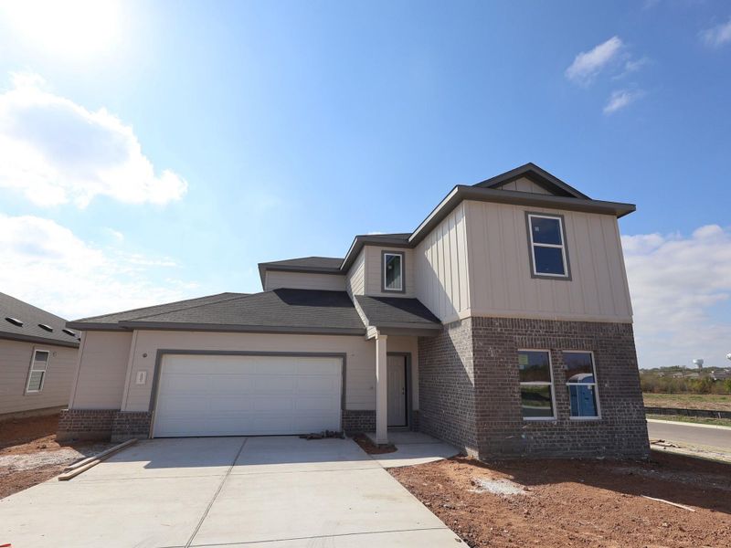 Front exterior of a new home in Carillon, Manor, TX, highlighting curb appeal (Image 6).