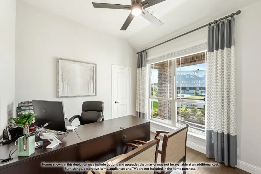 Home office with dark wood desk, ceiling fan, and large window with gray curtains