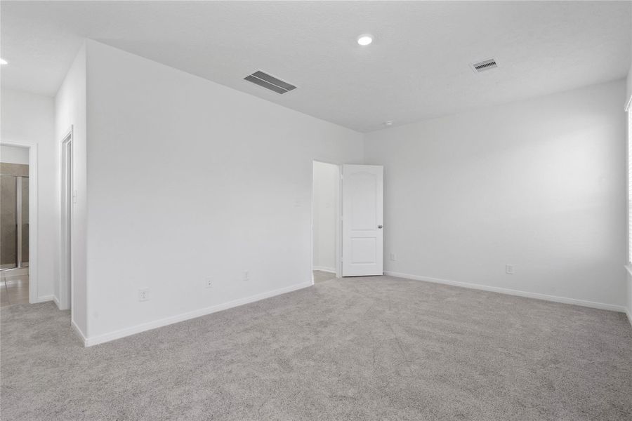 Additional view from primary bedroom looking down hallway to walk-in closet and primary bathroom.