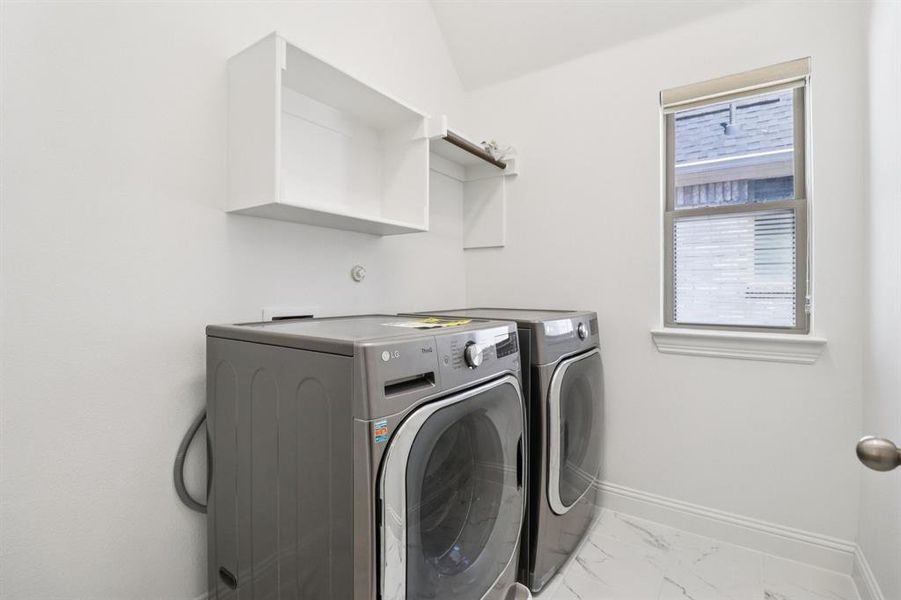 Laundry room featuring light marble finish floors and washer and dryer Laundry room featuring light marble finish floors and washer and dryer