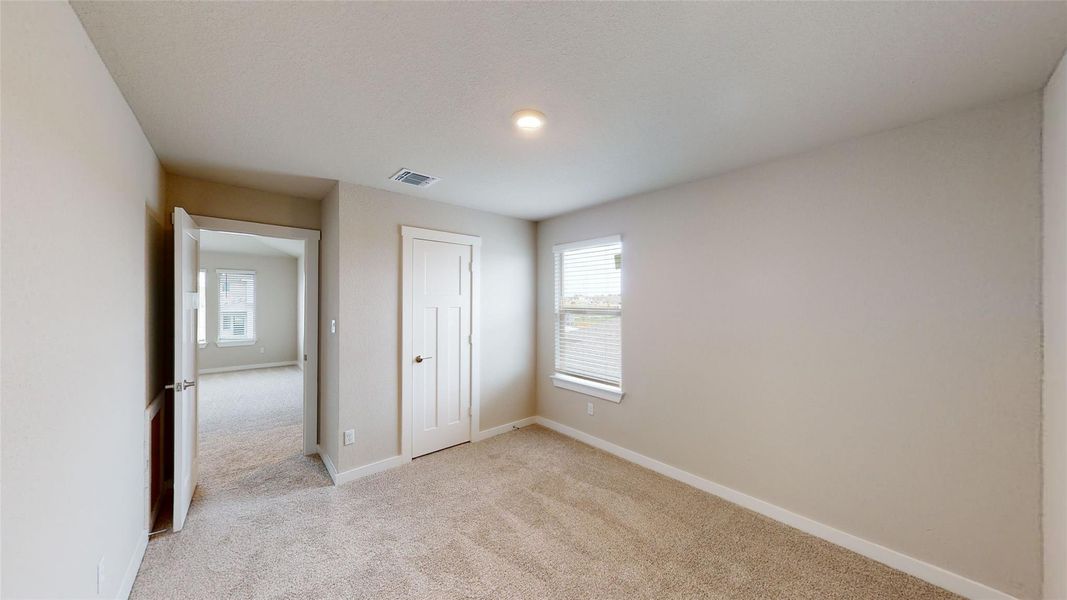 Unfurnished bedroom with light colored carpet and a closet