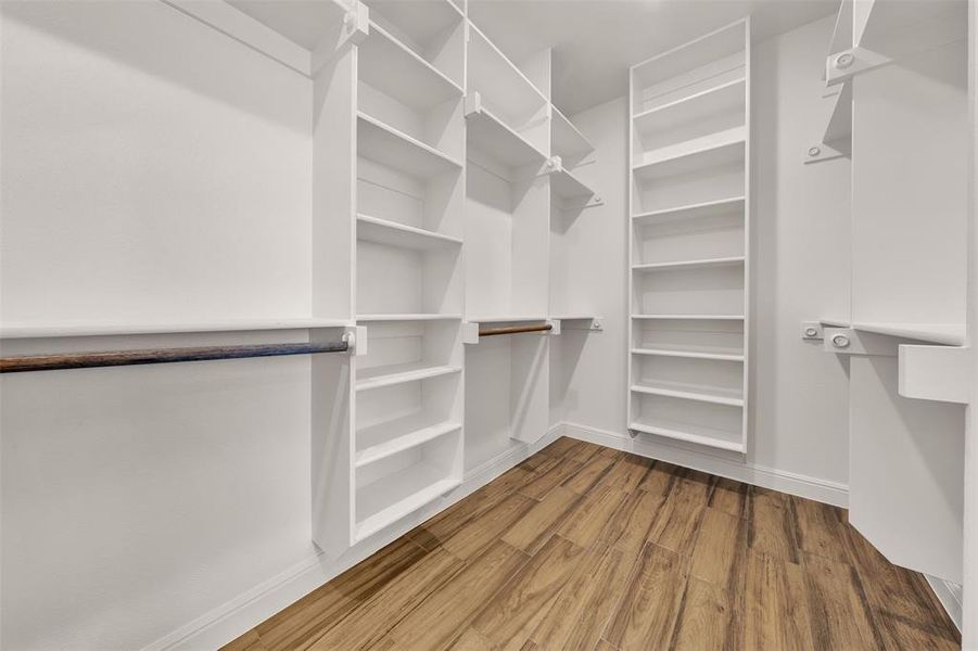 Walk in closet featuring wood finished floors Walk in closet featuring wood finished floors