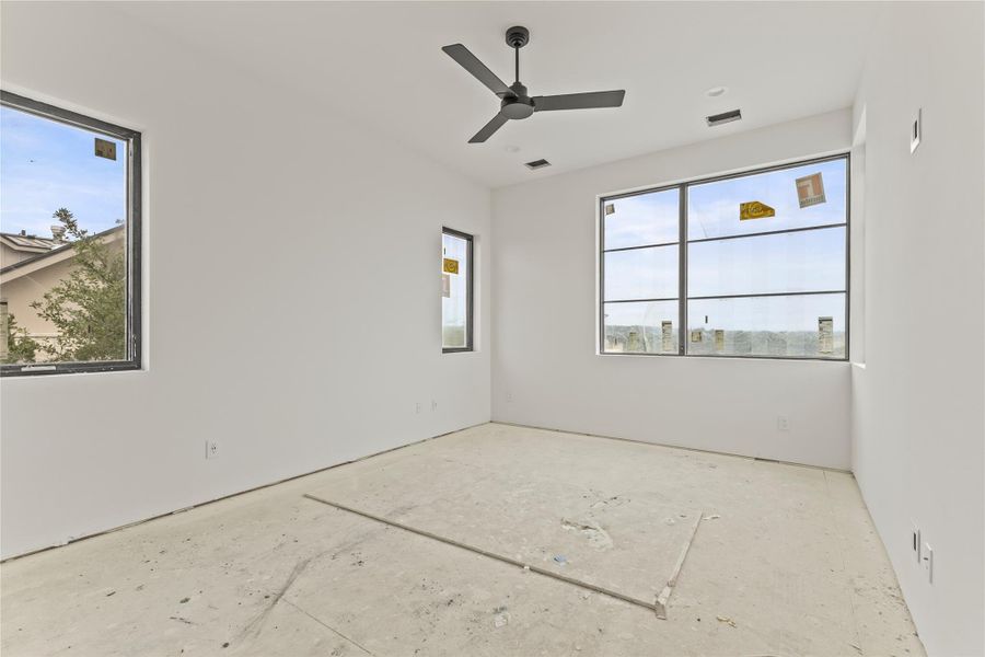 Spacious room featuring multiple large windows, a modern ceiling fan, recessed lighting, and clean white walls