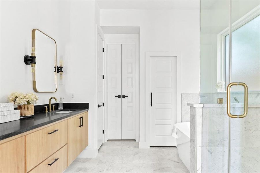 Bathroom featuring a shower with door and vanity