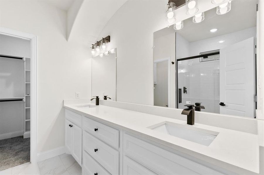 Full bath with a stall shower, marble finish floor, a sink, and a walk in closet Full bath with a stall shower, marble finish floor, a sink, and a walk in closet